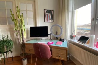 Person richtet ergonomischen Home‑Office‑Arbeitsplatz mit Monitor und Tastatur ein