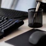 a computer keyboard and a mouse on a desk