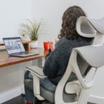 a woman sitting at a desk with a laptop