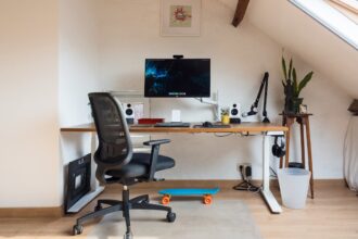 Ein moderner höhenverstellbarer Schreibtisch in einem hellen Home Office, der sich gerade in der Bewegung zwischen Steh- und Sitzhöhe befindet.