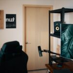 Ein schlanker Monitorarm hält einen ultrawiden Bildschirm über einem aufgeräumten Schreibtisch, schafft freie Arbeitsfläche.