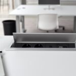 Ein moderner elektrisch höhenverstellbarer Schreibtisch in einem hellen Home-Office, der sich gerade in einer stehenden Position befindet.