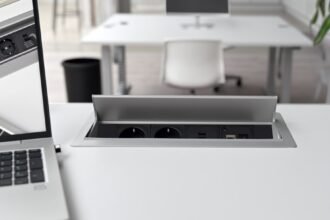 Ein moderner elektrisch höhenverstellbarer Schreibtisch in einem hellen Home-Office, der sich gerade in einer stehenden Position befindet.