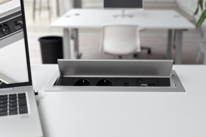 Ein moderner elektrisch höhenverstellbarer Schreibtisch in einem hellen Home-Office, der sich gerade in einer stehenden Position befindet.