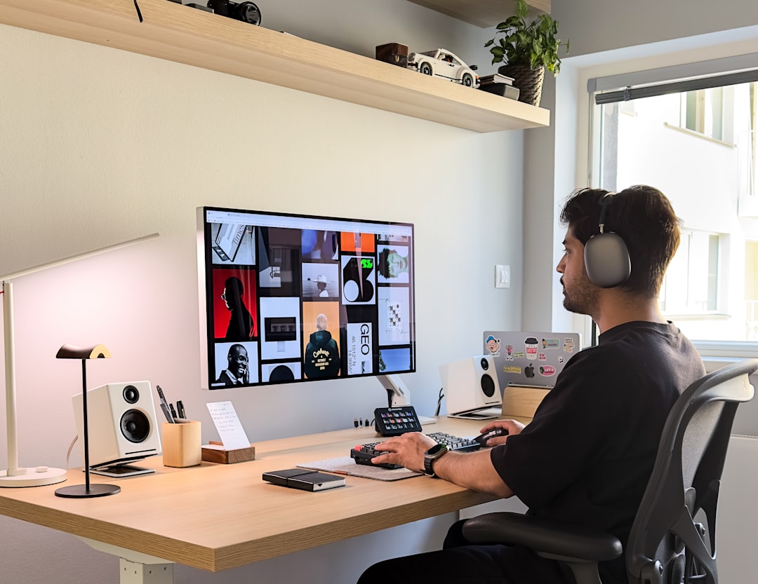 Ein moderner, ergonomischer schwarzer Büro-Kopfhörer (Jabra Evolve2 85) liegt auf einem aufgeräumten Schreibtisch im Home-Office, neben einem Laptop und einer Kaffeetasse.